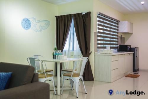 a kitchen and a table and chairs in a room at AnyLodge Waterfront Marina Island Pangkor in Lumut