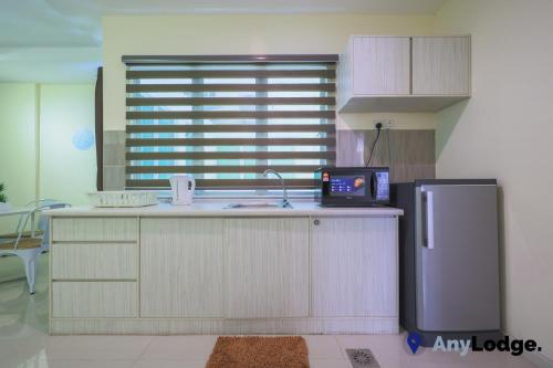 a kitchen with a counter top with a refrigerator at AnyLodge Waterfront Marina Island Pangkor in Lumut