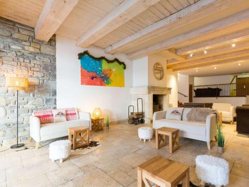 a living room with white furniture and a stone wall at Appartement Saint-Lary-Soulan, 4 pièces, 8 personnes - FR-1-296-489 in Saint-Lary-Soulan
