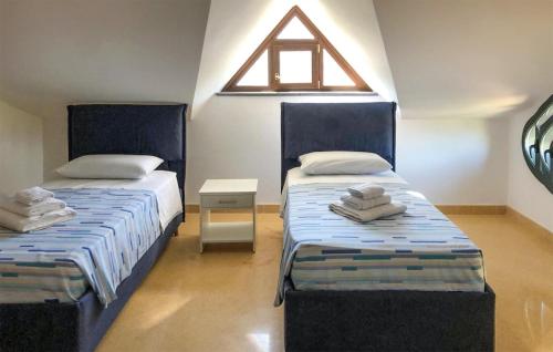 two beds in a room with a window at Gorgeous Home In Giffoni Sei Casali With Outdoor Swimming Pool in Giffoni Sei Casali