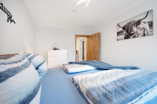 2 łóżka w pokoju z niebieską podłogą w obiekcie Fewo Traumschleife Nohen w mieście Nohen