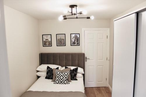 Schlafzimmer mit einem Bett mit schwarzen und weißen Kissen in der Unterkunft Reading's Peaceful Gem in Reading
