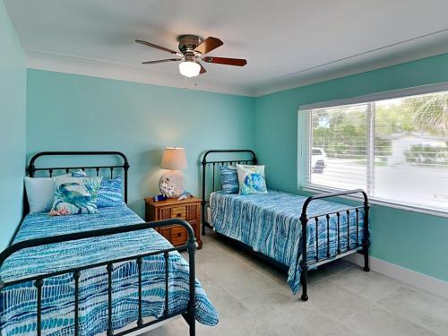 a bedroom with two beds and a ceiling fan at Tortuga Too in Fort Myers Beach