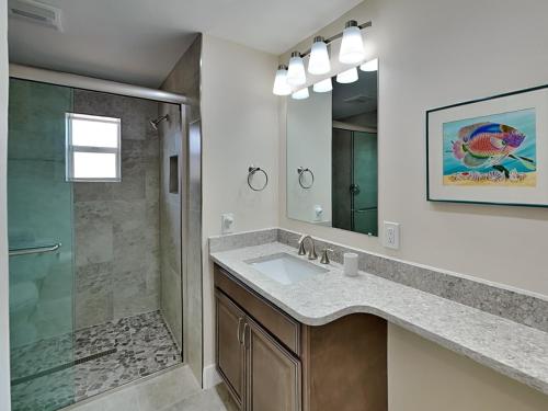uma casa de banho com um lavatório e um chuveiro em Tortuga Too em Fort Myers Beach