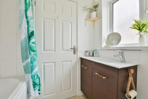 a bathroom with a sink and a shower curtain at Garden Station Dwelling in Rumney in Cardiff