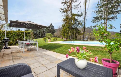 a patio with a table and an umbrella and a pool at 2 Bedroom Cozy Home In Tabre in Tabre