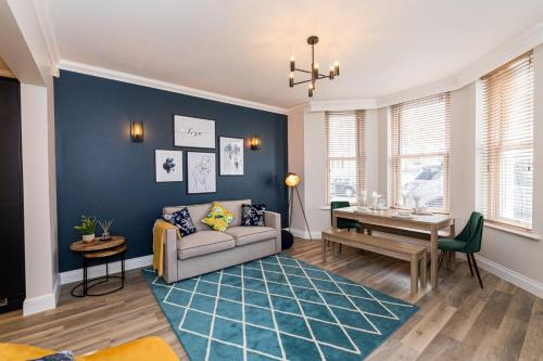 a living room with a couch and a table at Stylish home with garden near the beach in Bournemouth