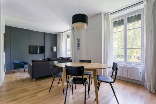 un salon avec une table, des chaises et un canapé dans l'établissement Hamac Suites - Le Bayard - 2 Bedrooms - Lyon 2, à Lyon