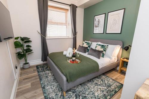 a bedroom with a bed with a green wall at Stylish home with garden near the beach in Bournemouth