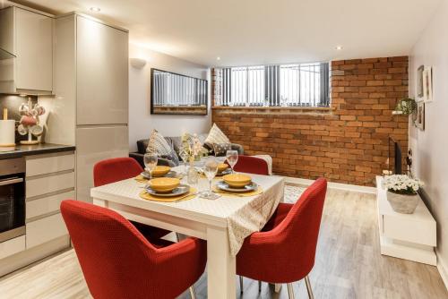 a kitchen and living room with a white table and red chairs at Charming retreat in Bradford in Bradford