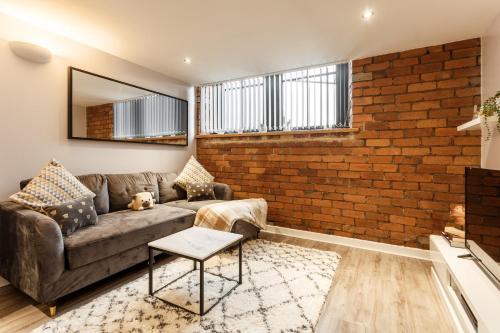 Una sala de estar con un sofá y una pared de ladrillos. en Charming retreat in Bradford, en Bradford