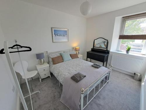 Schlafzimmer mit einem Bett, einem Schreibtisch und einem Bett in der Unterkunft Beautiful 2BR Home close to Beachfront in Weston-super-Mare