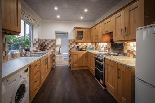 a large kitchen with wooden cabinets and a dishwasher at Delightful Family Home in Blackpool in Blackpool