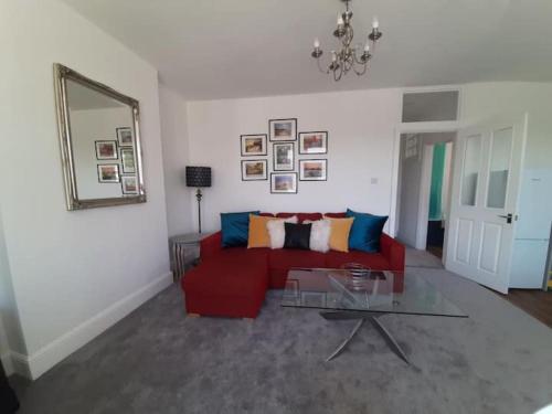 a living room with a red couch and a glass table at Beautiful 2BR Home close to Beachfront in Weston-super-Mare