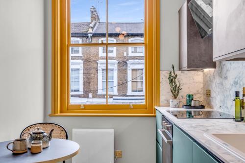 a kitchen with a window and a table at Hammersmith Residences by MySquare in London