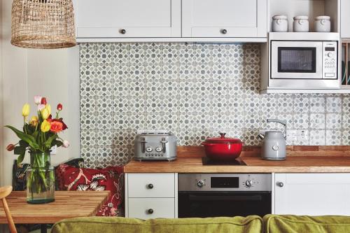 a kitchen with a counter with a microwave and a table at No.26 By The Sea in Oban