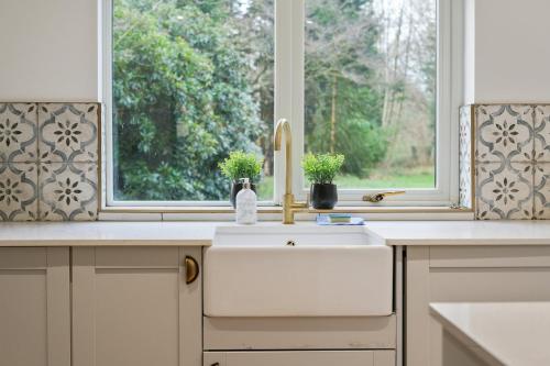 a kitchen with a sink and a window at Victorian Summer Retreat in Liverpool in Knowsley