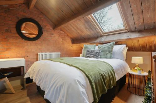ein Schlafzimmer mit einem Bett und einer Ziegelwand in der Unterkunft Modern 5BR Victorian Home in Liverpool in Knowsley