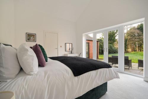 a white bedroom with a large bed with pillows at Modern 5BR Victorian Home in Liverpool in Knowsley