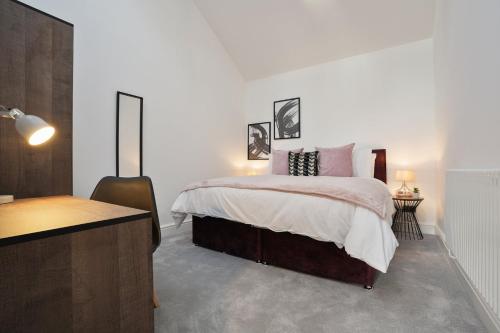 a white bedroom with a bed and a desk at Modern 5BR Victorian Home in Liverpool in Knowsley