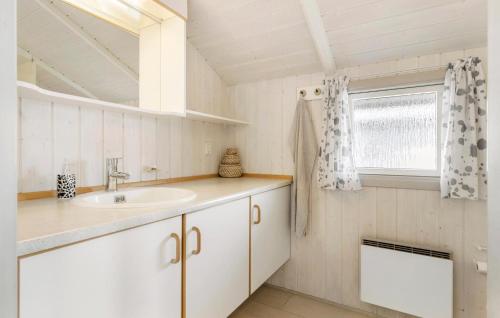 een witte badkamer met een wastafel en een raam bij 2 Bedroom Lovely Home In Otterup in Otterup