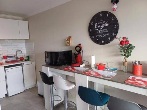 une cuisine avec un comptoir et quelques chaises bleues dans l'établissement Charmant appartement climatisé avec terrasse - Bormes-les-Mimosas - FR-1-308-192, à Bormes-les-Mimosas