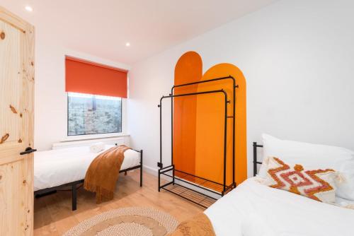 a bedroom with two beds and a mirror at Seafront retreat in Margate in Kent