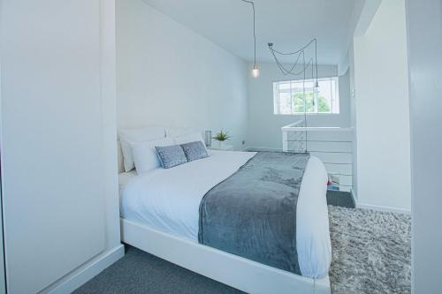 a bedroom with a white bed in a white room at Luxury retreat in Shirley North in Elmers End