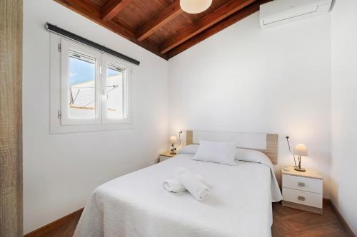 1 dormitorio con cama blanca y ventana en Villa Novo Sancti Petri 2, en Novo Sancti Petri