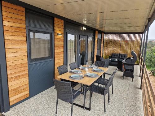 a table and chairs on a patio with a house at Mobile Homes Albatross Pirovac in Pirovac