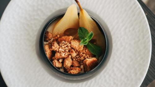 a bowl of food with nuts and a spoon at Hôtel De La Marine in Arromanches-les-Bains