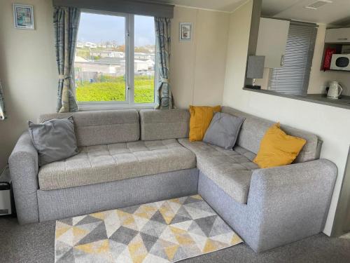 ein Wohnzimmer mit einem grauen Sofa und gelben Kissen in der Unterkunft Littlesea Haven fleetview in Weymouth