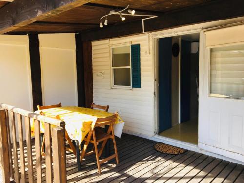 une table sur le pont d'une maison dans l'établissement Mobil-home avec grand jardin, à Sérignan
