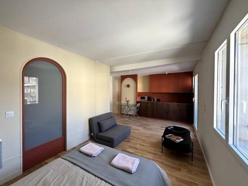 un salon avec un lit et une chaise dans l'établissement Magnifique studio + balcon au cœur d'Aix, à Aix-en-Provence
