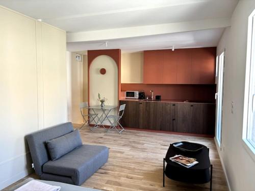 un salon avec un canapé et une table dans l'établissement Magnifique studio + balcon au cœur d'Aix, à Aix-en-Provence