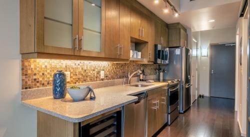 a kitchen with wooden cabinets and stainless steel appliances at Via 6 in Seattle