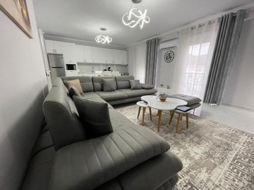 een woonkamer met een bank en een tafel bij Luxury Apartment Korca in Korçë