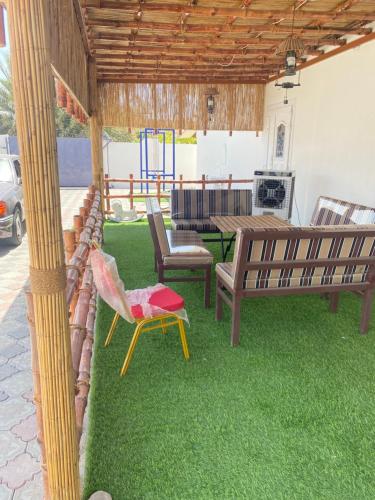 a patio with benches and a table and grass at Apartment with swimming pool in Wāsiţ