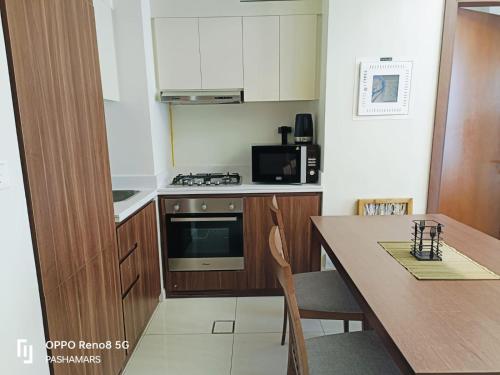 a small kitchen with a table and a stove top oven at Reva Residence Luxurious 2 BHK in Dubai