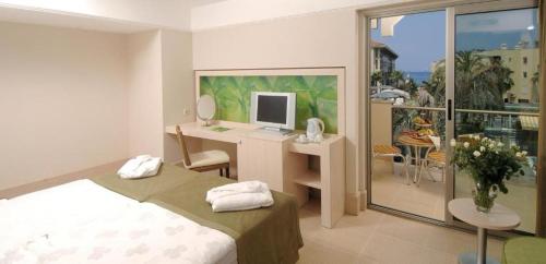 a bedroom with a bed and a desk with a computer at Ambassador Hotel & Spa- All Inclusive in Kemer