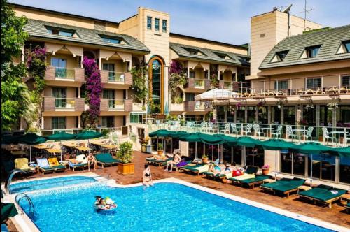a pool at a hotel with people sitting around it at Ambassador Hotel & Spa- All Inclusive in Kemer