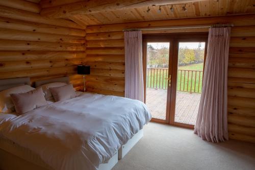 a bedroom with a bed and a sliding glass door at Pheasant's Roost in Foxton