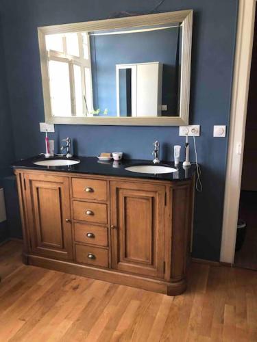 une salle de bain avec deux lavabos et un miroir dans l'établissement Maison de maître - Les Marizys, à Vouziers