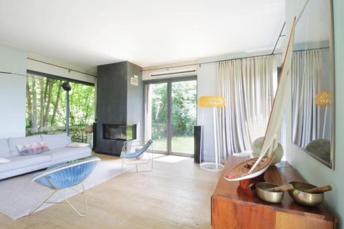 ein Wohnzimmer mit einem weißen Sofa und blauen Stühlen in der Unterkunft Family villa with swimming pool in Aiguebelette-Le-Lac in Aiguebelette-le-Lac