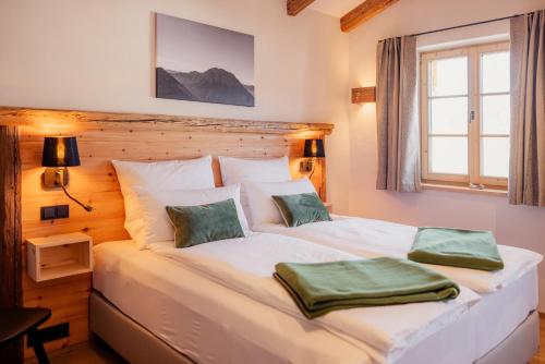 a bedroom with a white bed with two pillows on it at Chalet in Fischbachau