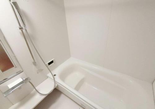 a white bathroom with a tub and a toilet at OvalMountainLodge - Vacation STAY 34543v in Hakuba