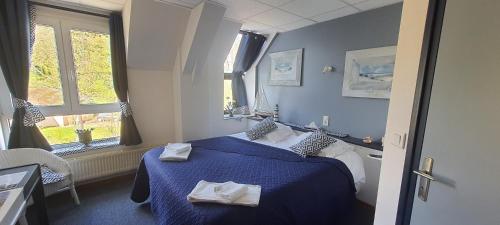 a hotel room with a blue bed and a window at Abbaye de Belval in Troisvaux