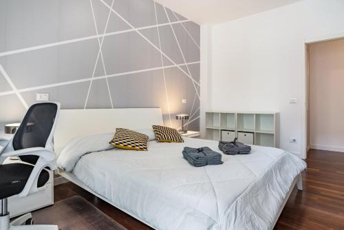 a bedroom with a white bed and a chair at Casa Grazioli in Trento