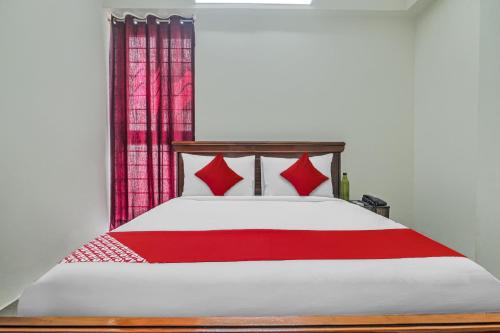 a bedroom with a bed with a red blanket at Collection O Manikonda - Managed by Company in Gachibowli