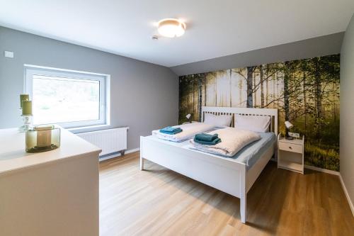 a bedroom with a bed with a painting on the wall at Ferienwohnungen am Weserstrand in Bodenwerder